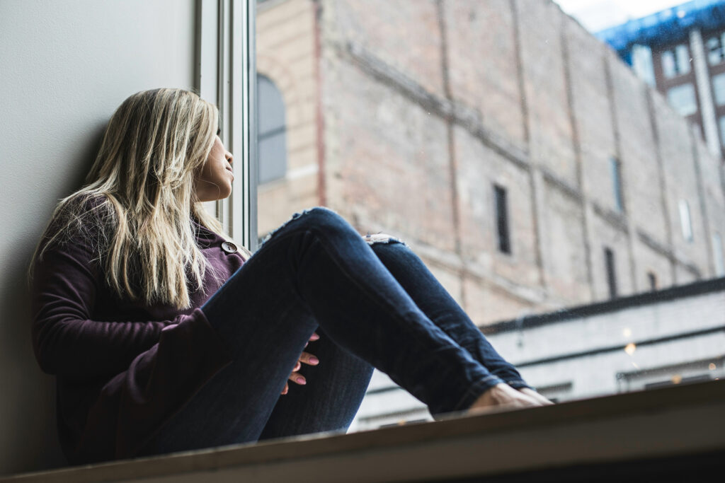 Woman sitting and looking out a window
